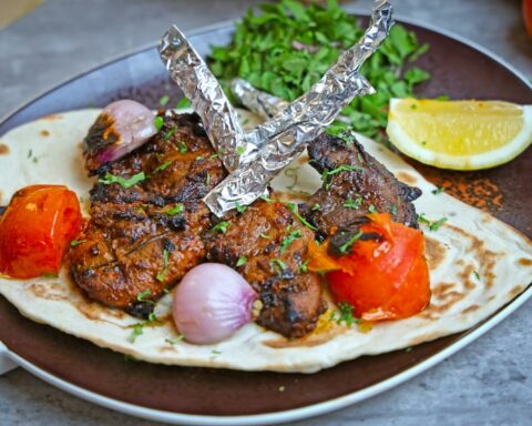 A plate with a flatbread with meat and vegetables